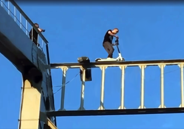 Парень катался на электросамокате на верхушке Пешеходного моста. Фото: Скриншот