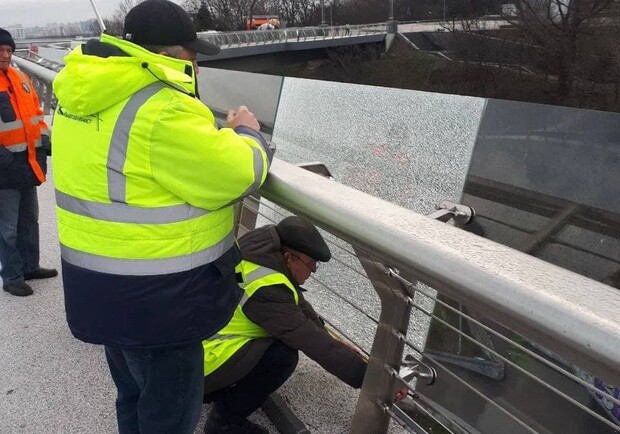 Вандалы разбили на велопешеходном мосту в Киеве стекло: его уже заменяют. 