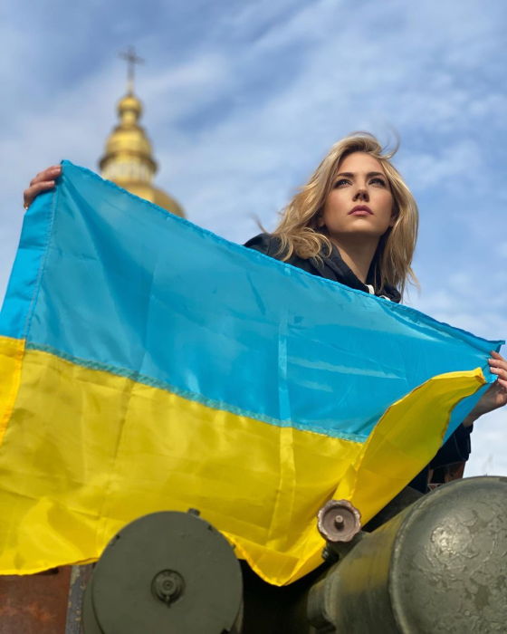 Фото Кэтрин Винник с украинским флагом.