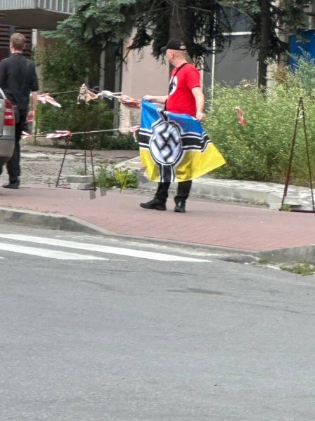 Мужчина демонстрирует флаг со свастикой Мужчина демонстрирует флаг со свастикой в Печерском районе Киева